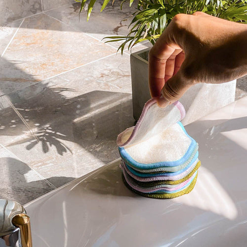 Hand Grabbing Bamboo Cotton Rounds In Bathroom