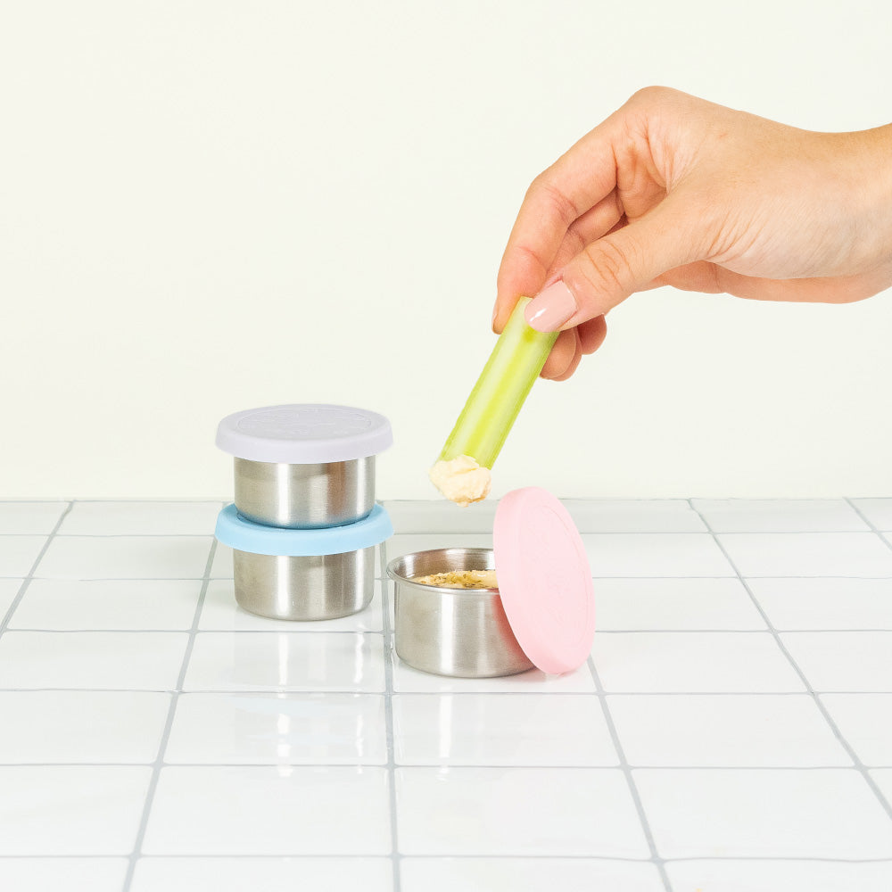 Dipping Celery Hummus In Reusable Sauce Containers